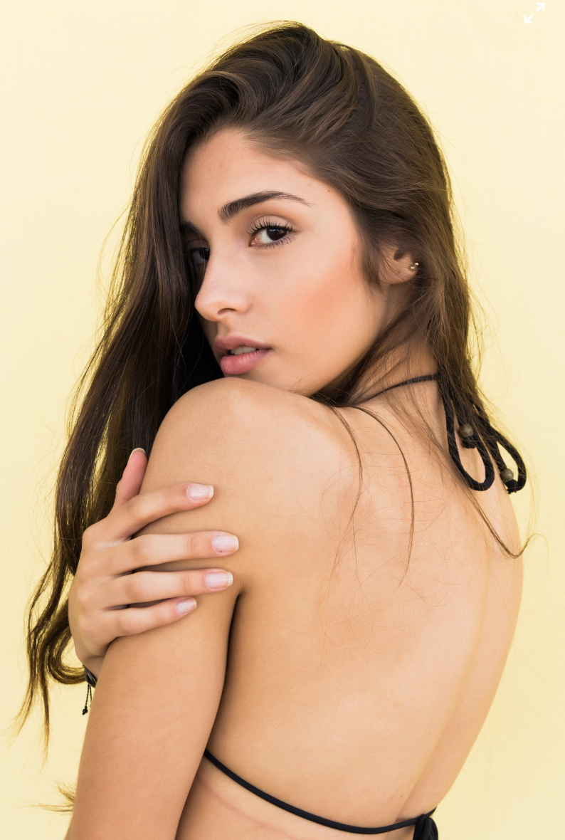 woman with dark hair with her head turned back