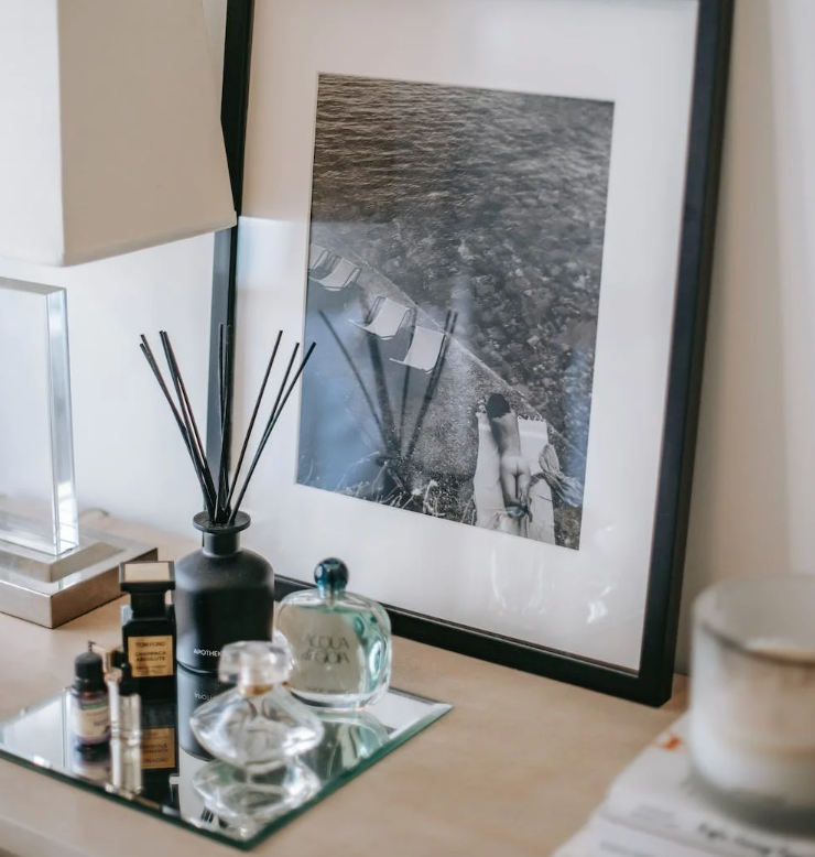 an assortment of mini perfume bottles on a table in front of a black and white photo