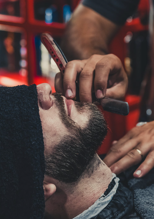 man getting his beard trimmed and shaped at a barbershop