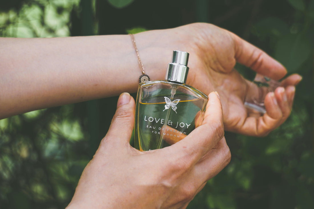 woman spraying a perfume called Love and Joy eau de parfum on her wrist