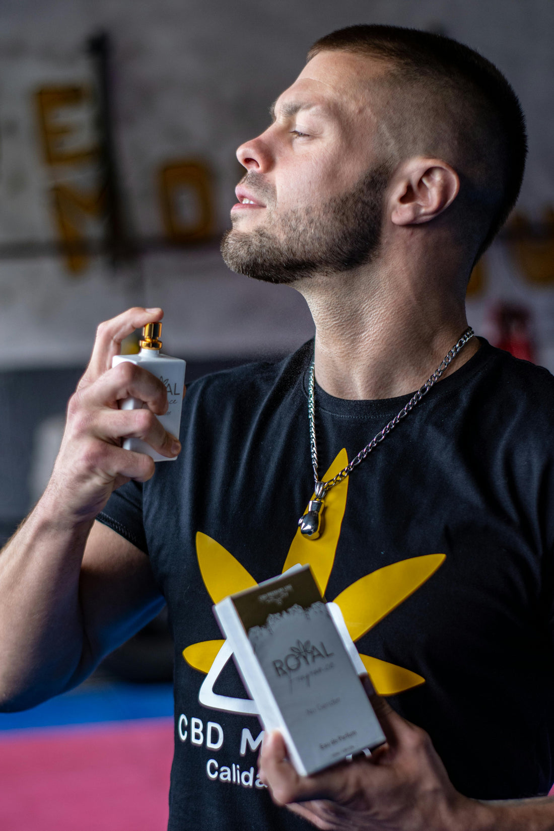 a fraghead in blue shirt spraying white cologne on his neck