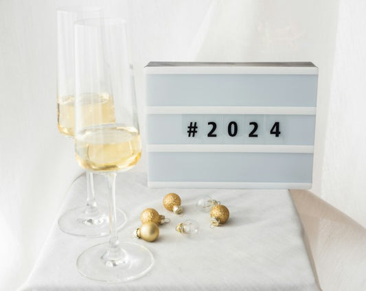 2 champagne glasses next to a sign that reads #2024