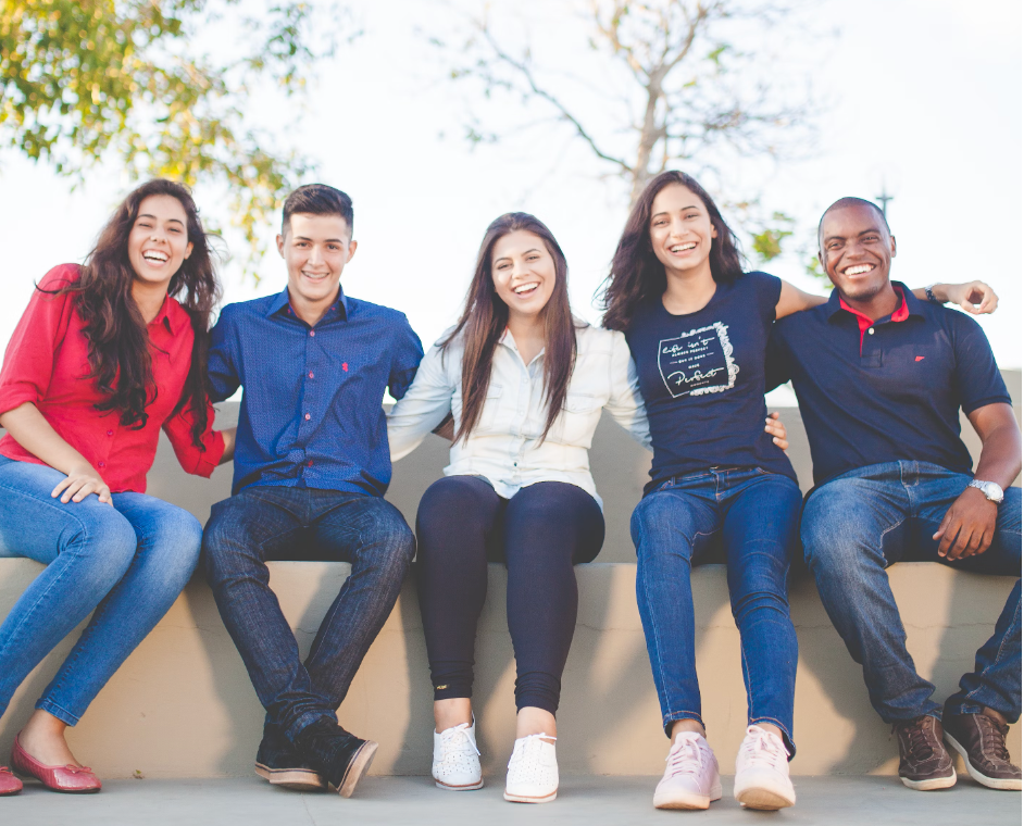 5 smiling students posing outside for a photo