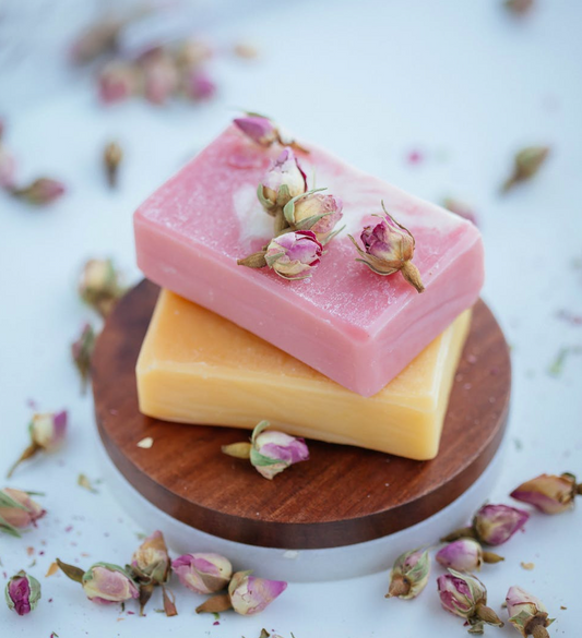 two bars of scented soaps and flowers