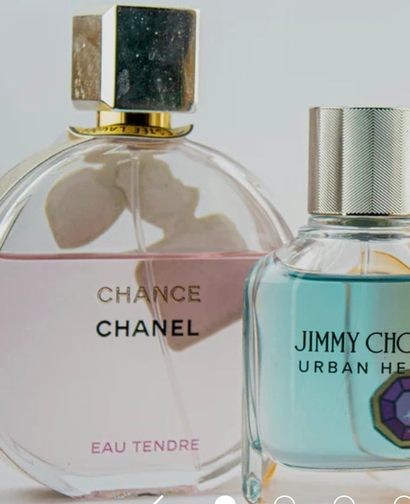 a bottle of chance eau tendre by chanel to the left of urban hero by jimmy choo