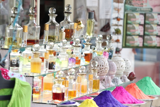 multiple rows of beautiful colorful perfume bottles placed in a shop
