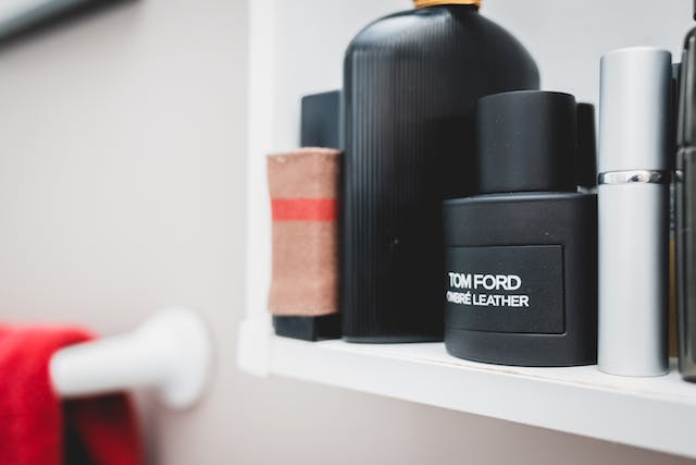 a few bottles of cologne on a bathroom shelf including tom ford's ombre leather