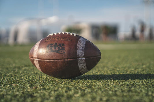 photo of a wilson football on a grassy field