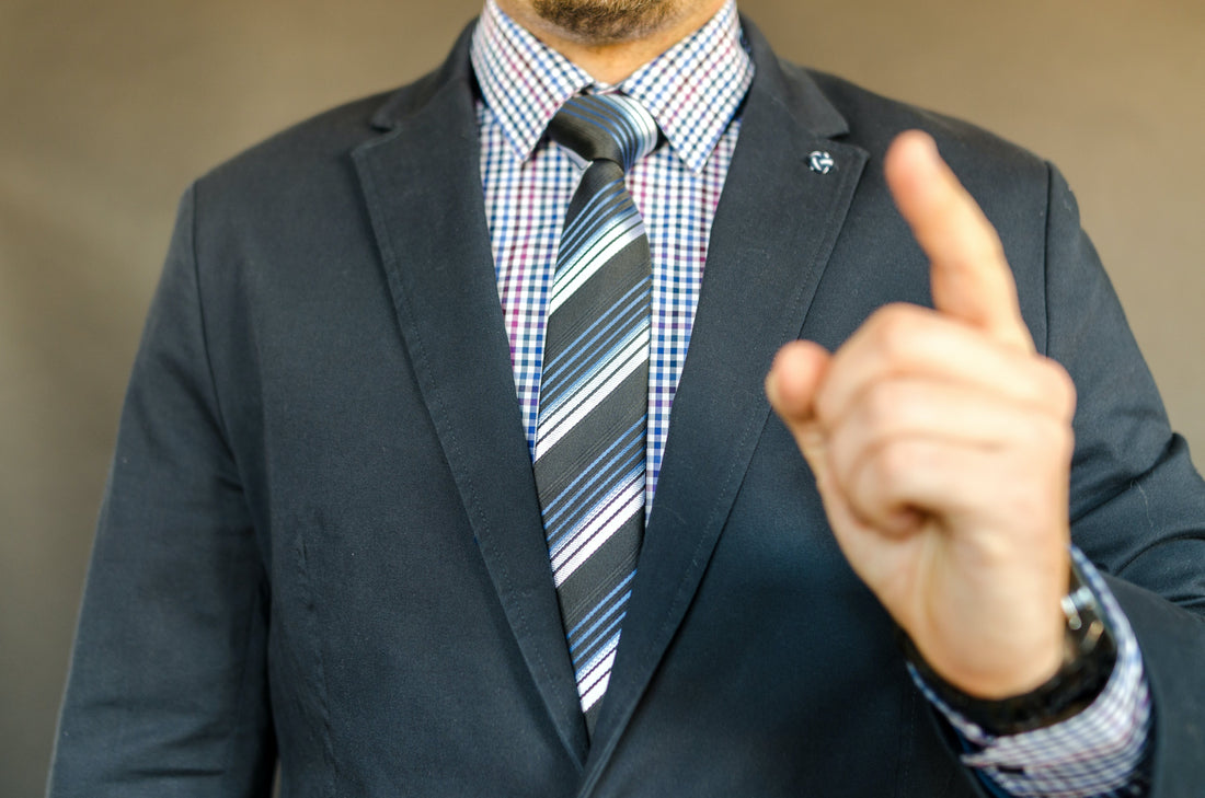 boss and employer in a suit and tie raising his finger