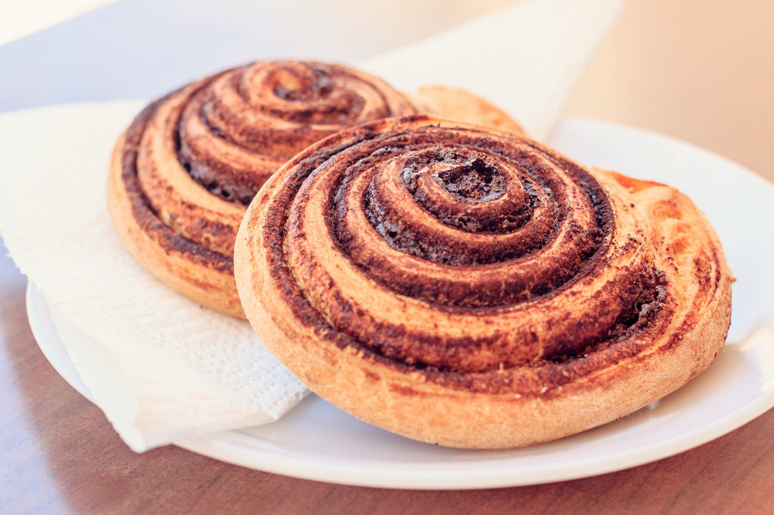 a close-up photo of 2 fresh cinnamon rolls on a plate
