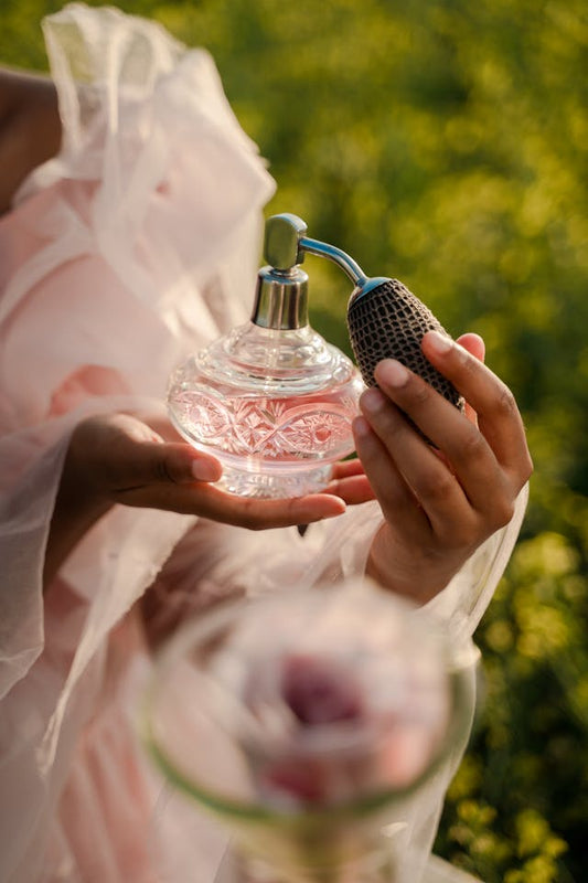 woman holding a Marilyn Miglin perfume bottle