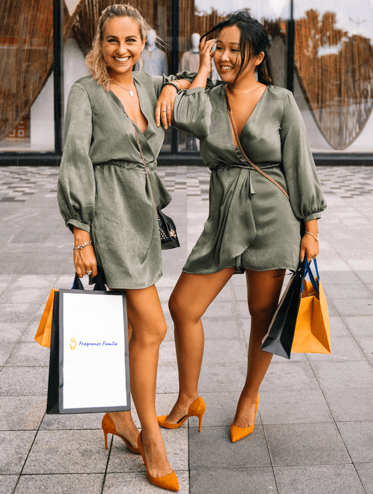 2 smiling women posing with fragrance familia shopping bag