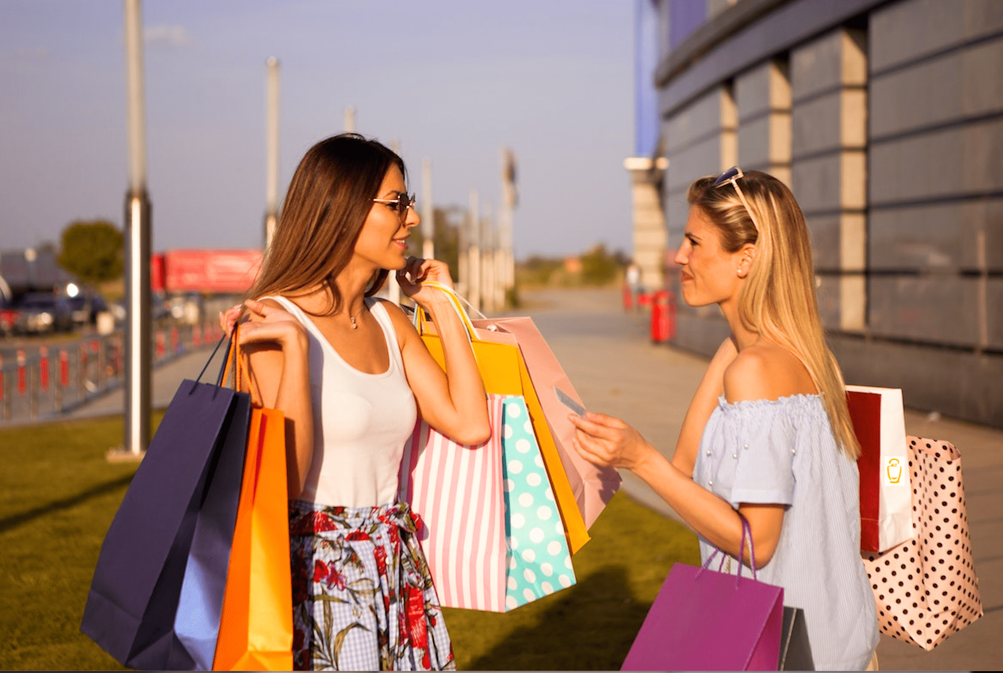 2 smiling women holding shopping bags